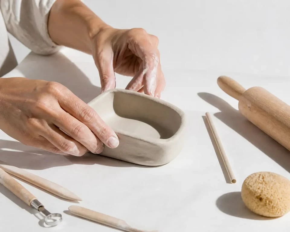 Idée de création avec de l'argile : mains modelant une pièce simple avec du matériel de base